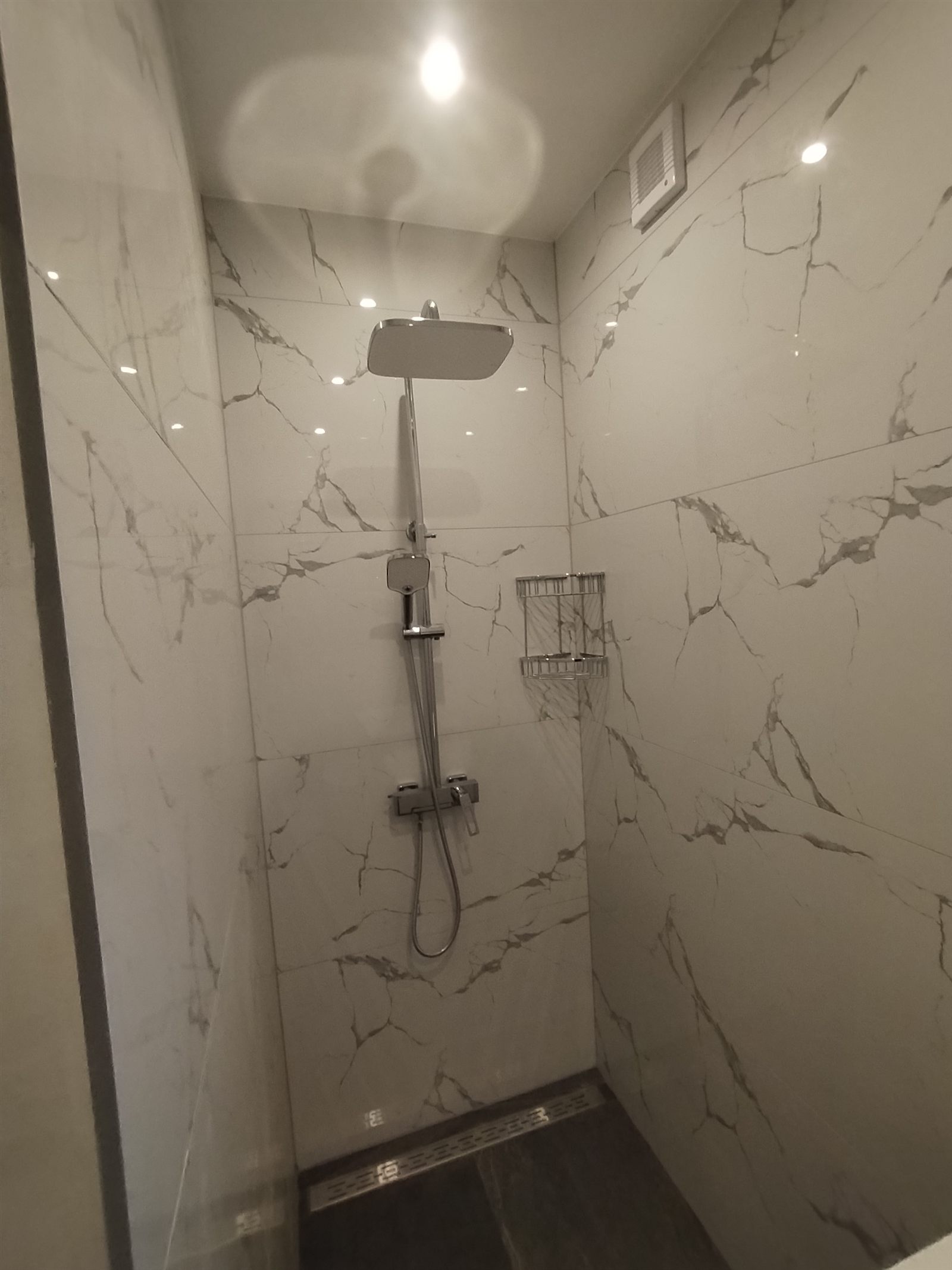 Salle de bain en marbre avec douche vitrée