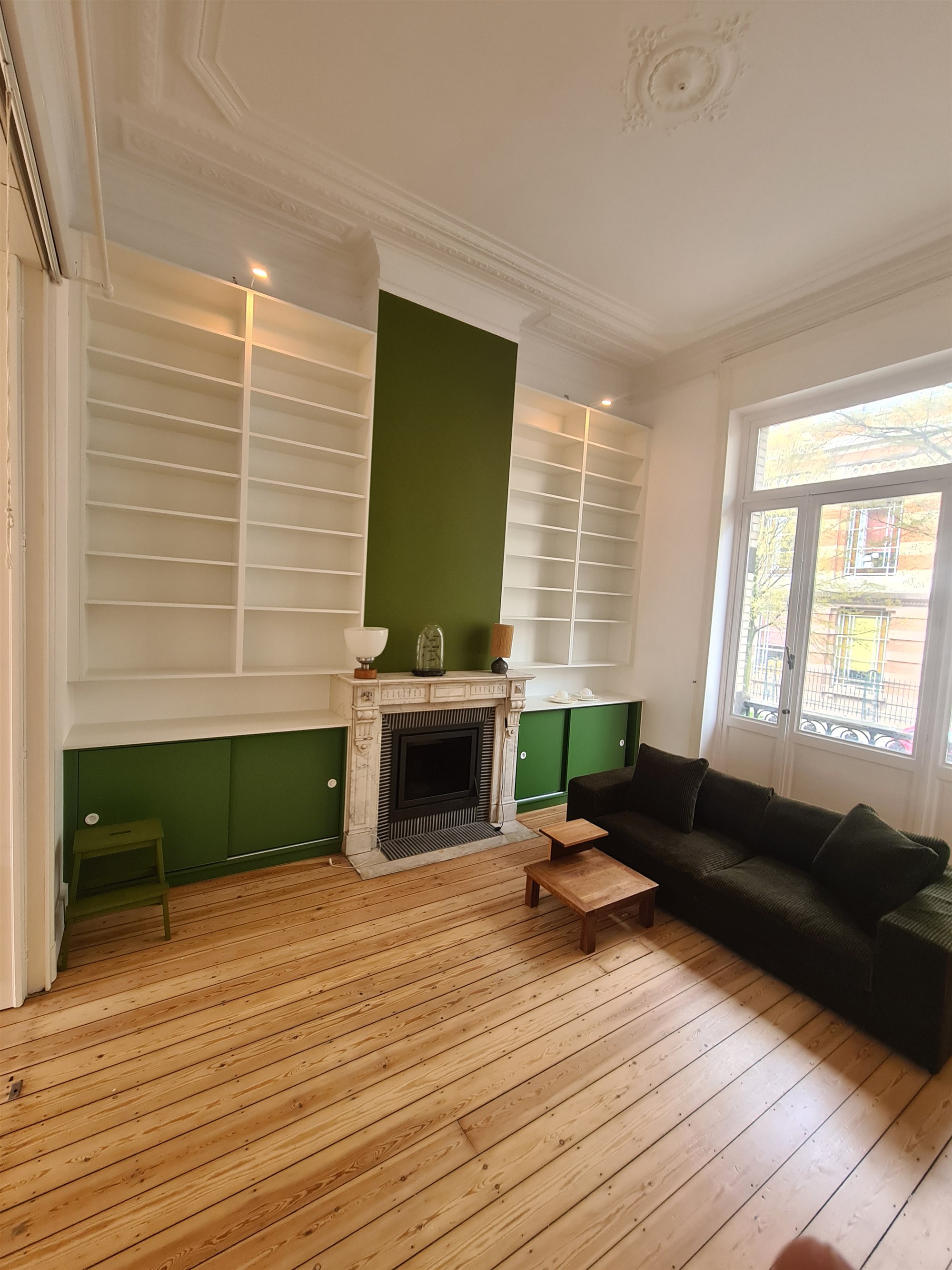 Living room with built-in bookcase and antique marble fireplace